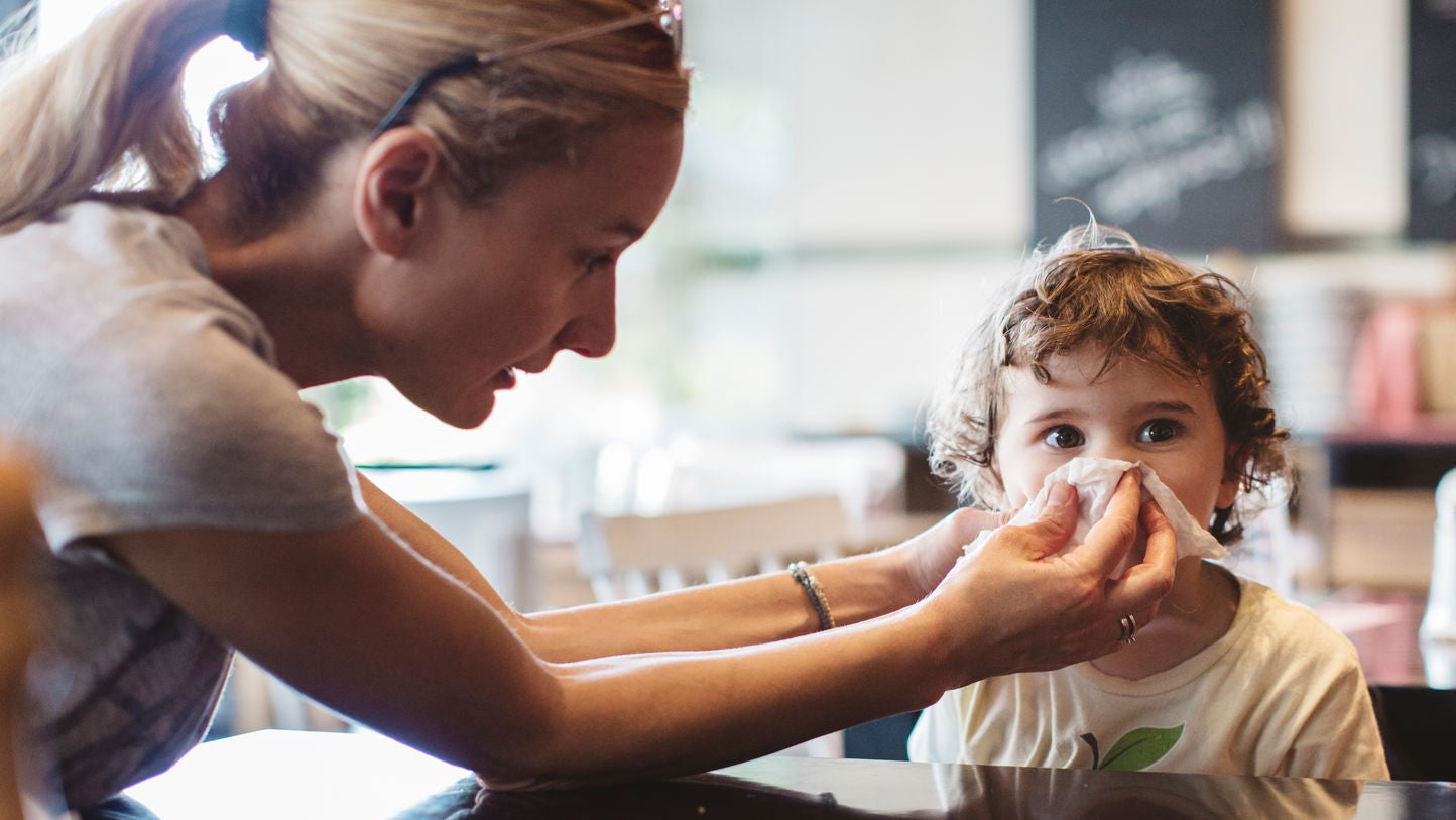 Mother wiping child's nose