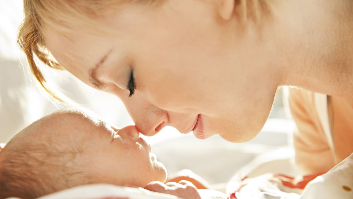 Close-up view of a woman gently touching noses with a baby