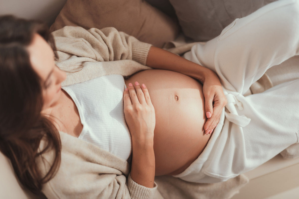 A pregnant woman gently cradling her belly